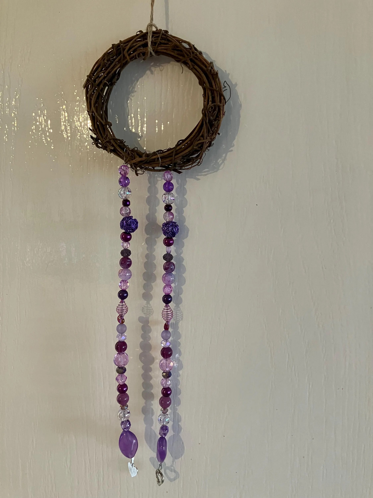 Beautiful handmade sun catchers hanging from a wicker hoop